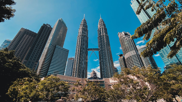 Vue en contre-plongée des tours jumelles Petronas à Kuala Lumpur avec un arrière-plan de ciel dégagé