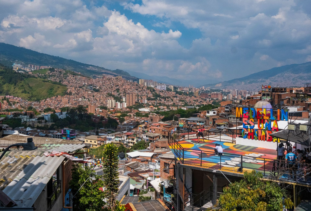 Vue panoramique du paysage urbain vibrant de Medellín et des montagnes sous un ciel dégagé.