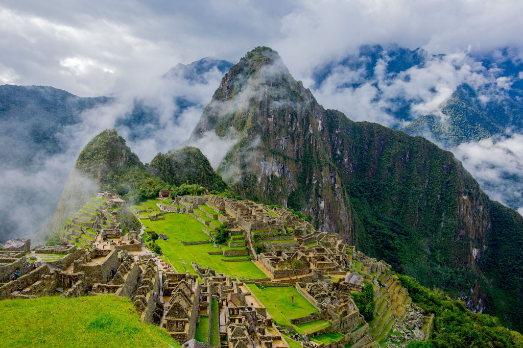 Vue aérienne spectaculaire des ruines de Machu Picchu entourées de montagnes verdoyantes et de brume