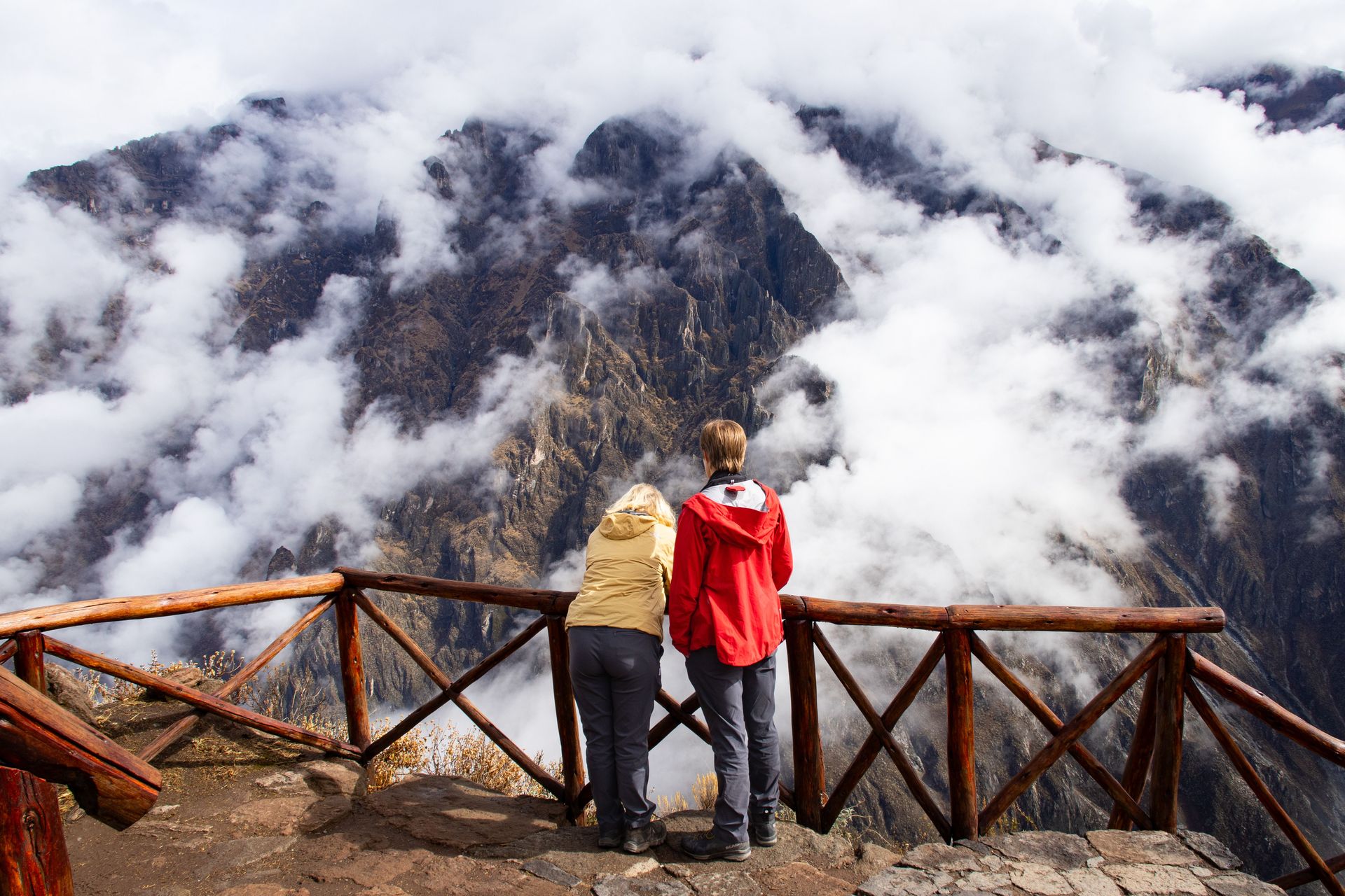 Deux randonneurs admirent la vue époustouflante du Canyon de Colca sous un ciel nuageux à Cabanaconde, Arequipa.
