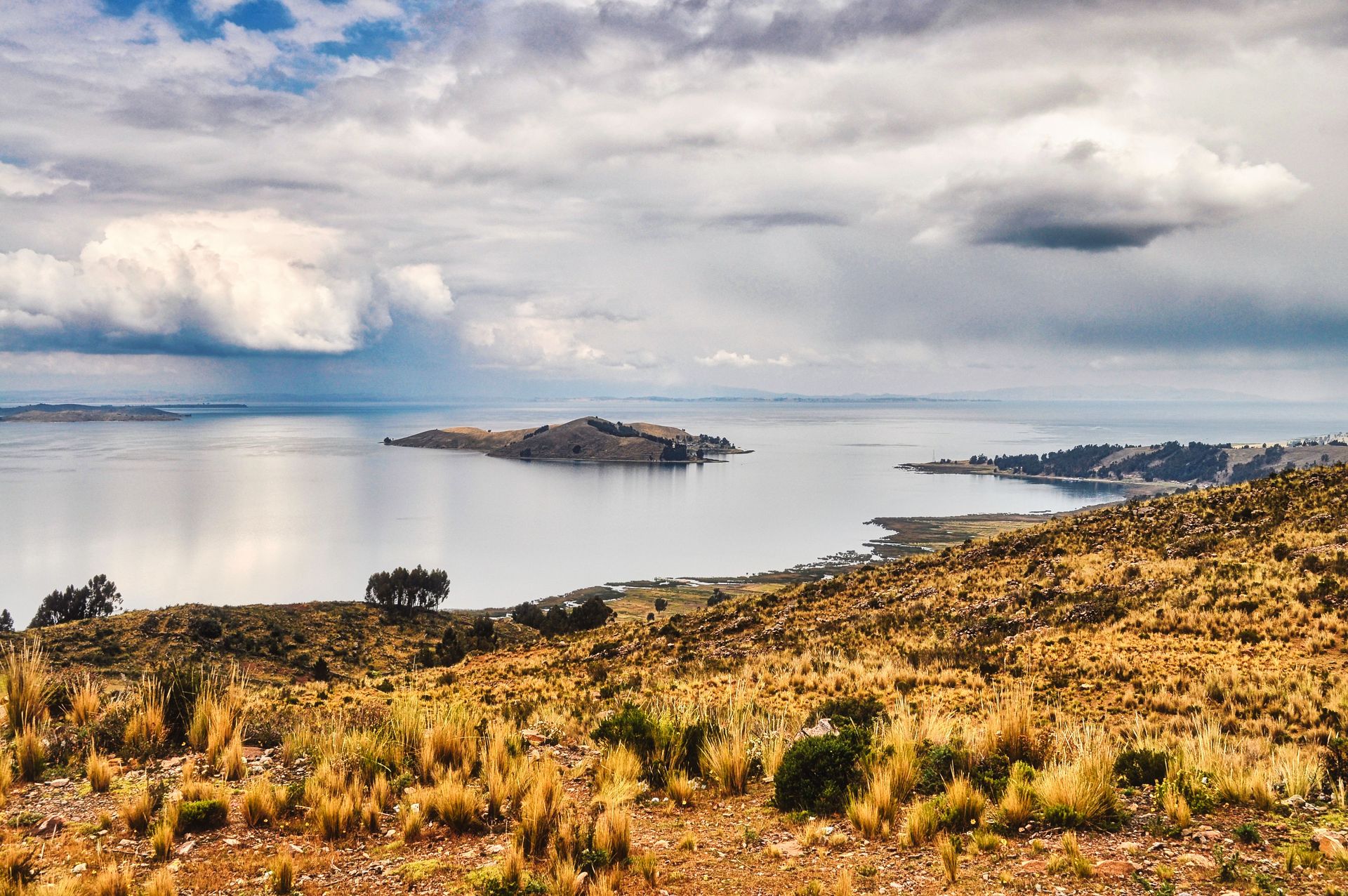 Paysage à couper le souffle du lac Titicaca avec une vue sur des îles lointaines sous des ciels dramatiques.