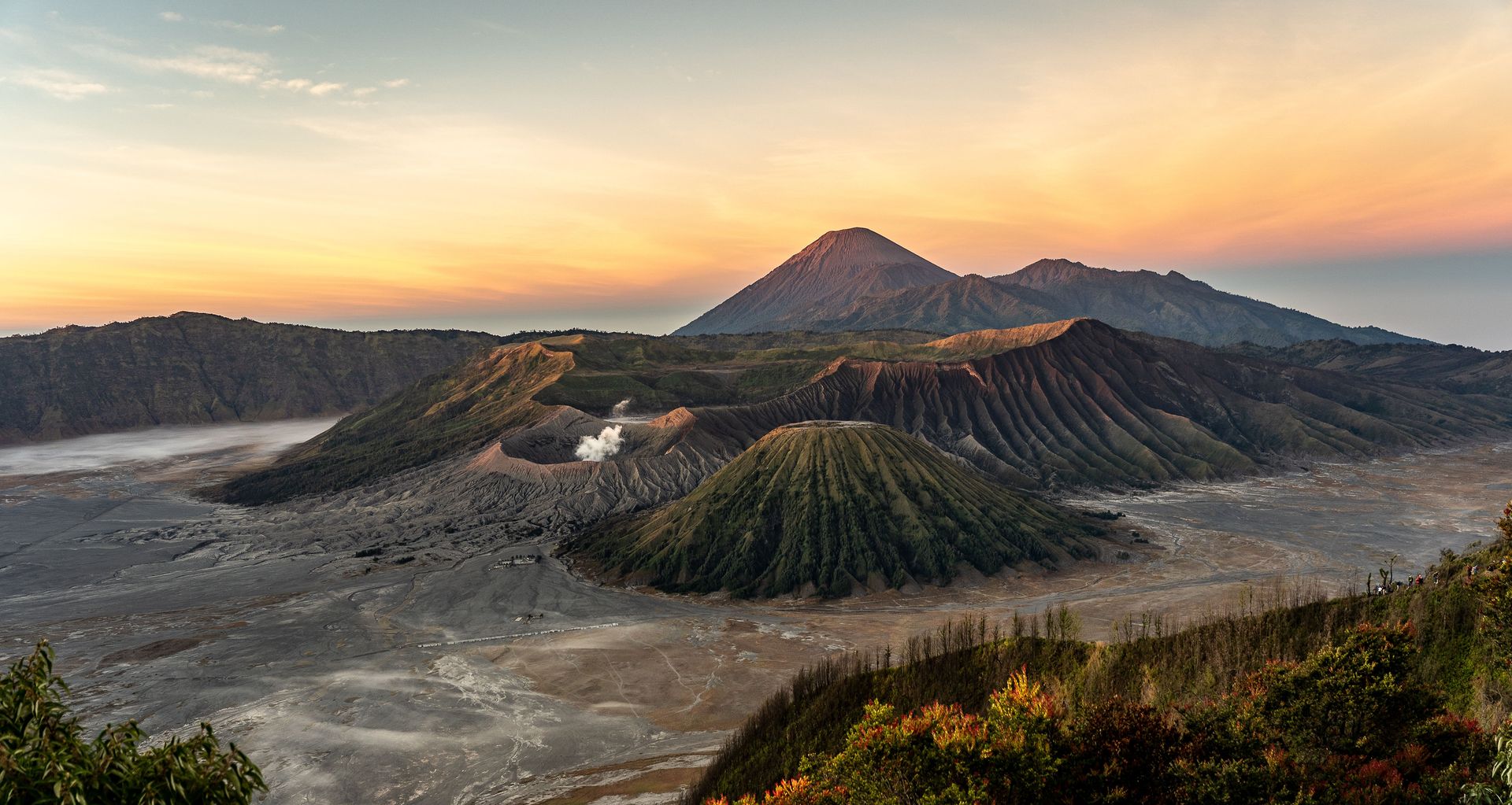 Une vue aérienne à couper le souffle du mont Bromo avec des cratères volcaniques au lever du soleil, mettant en valeur une beauté panoramique.