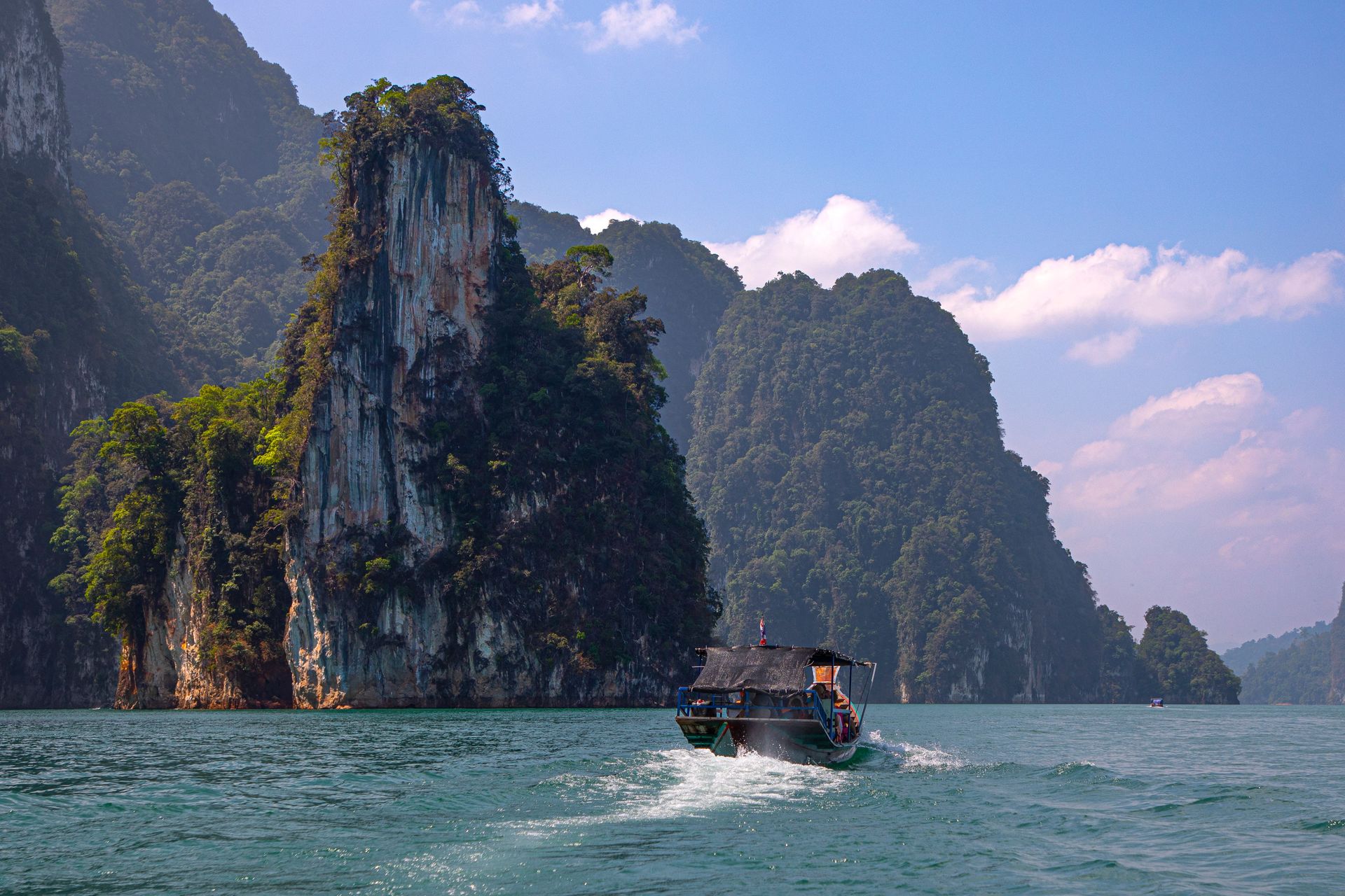 Vue pittoresque d'un bateau à longue queue sur le lac Cheow Lan, dans le parc national de Khao Sok, en Thaïlande.