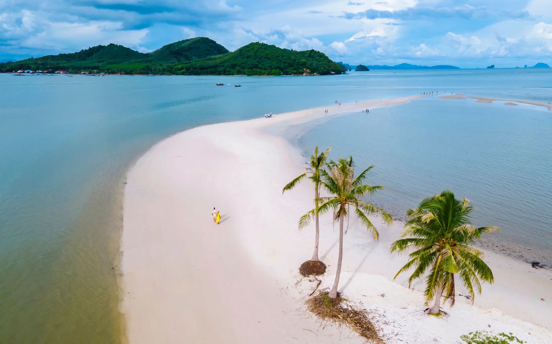 Couple d’hommes et de femmes marchant sur la plage de l’île de Koh Yao Yai en Thaïlande, plage de sable blanc et de palmiers