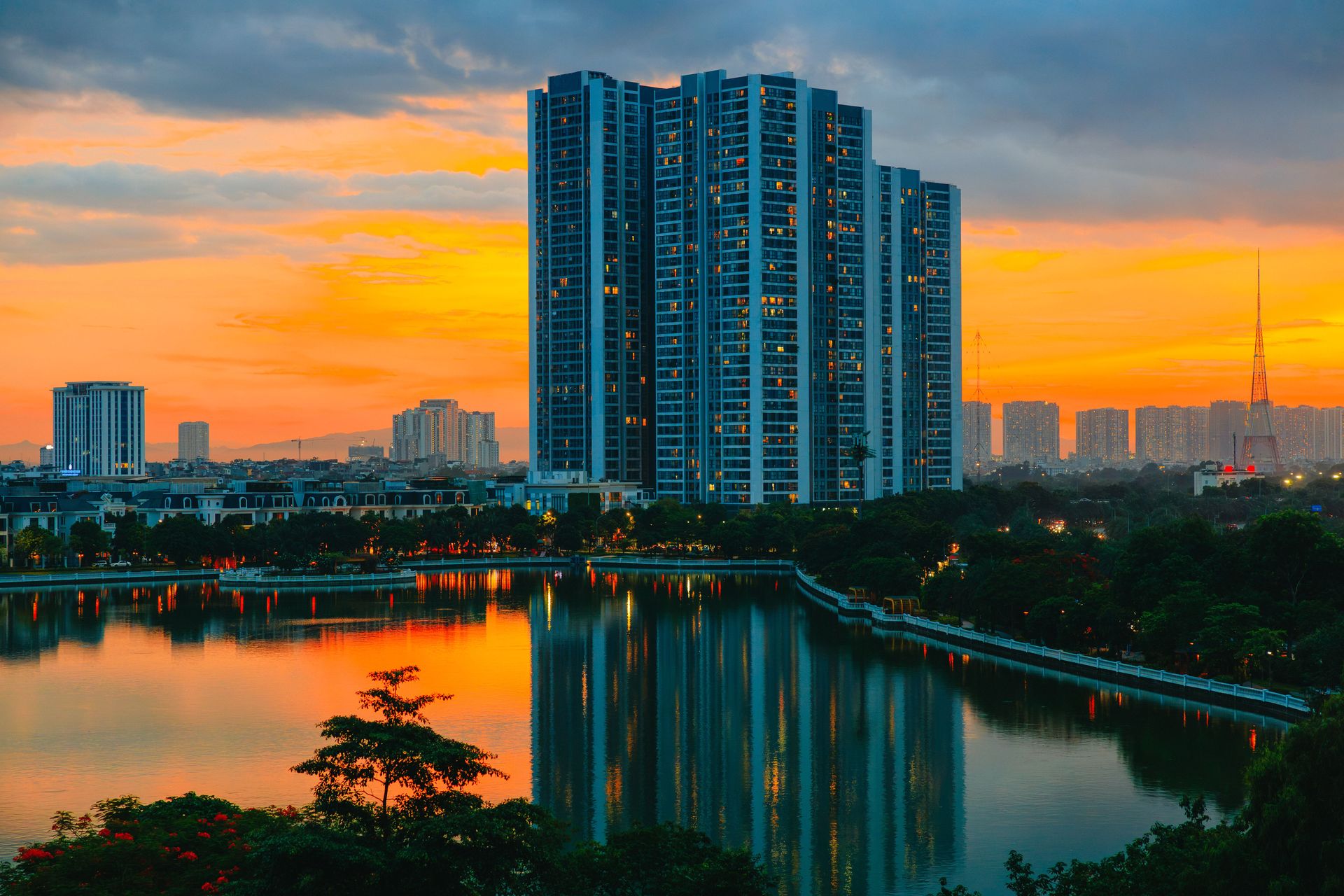 Magnifique paysage urbain avec des gratte-ciel se reflétant dans un lac serein au coucher du soleil.