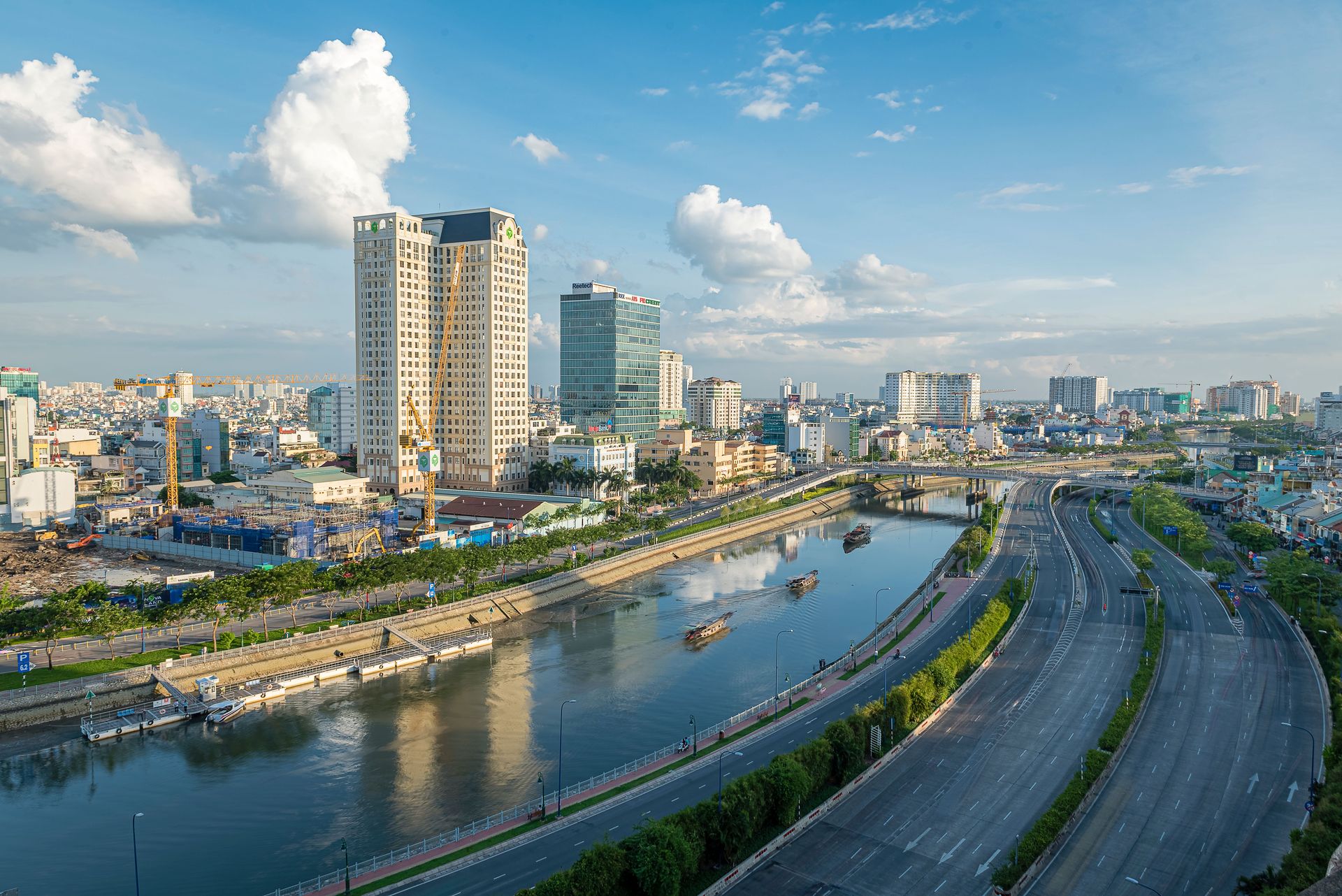 Une vue urbaine impressionnante de Hồ Chí Minh Ville avec des gratte-ciels, un canal et un ciel dégagé.