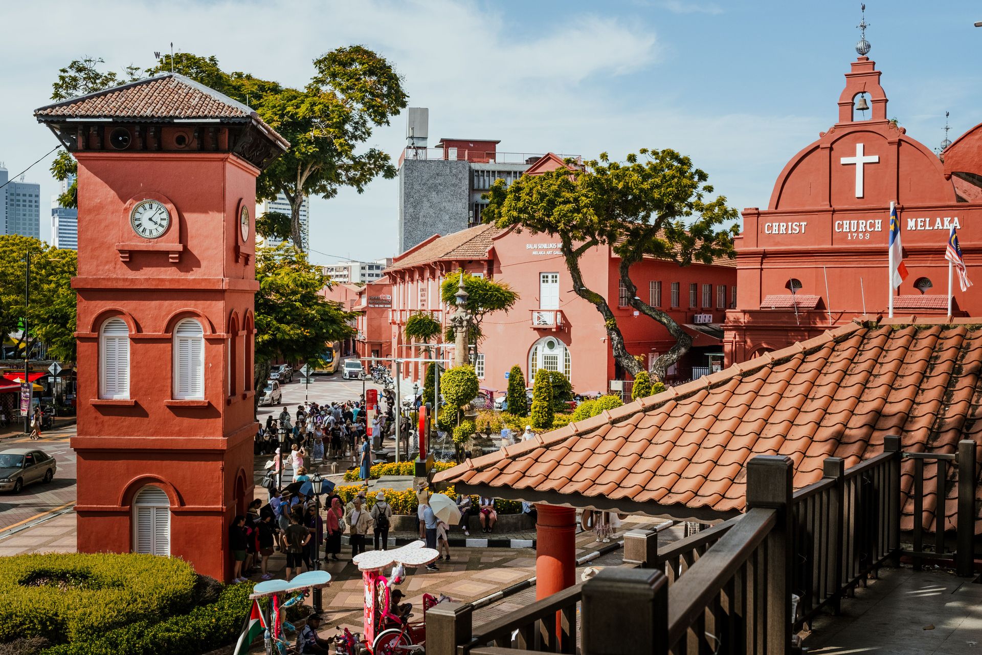 Scène vibrante de l'emblématique Église Christ de Malacca et de ses environs animés sous un jour éclatant.