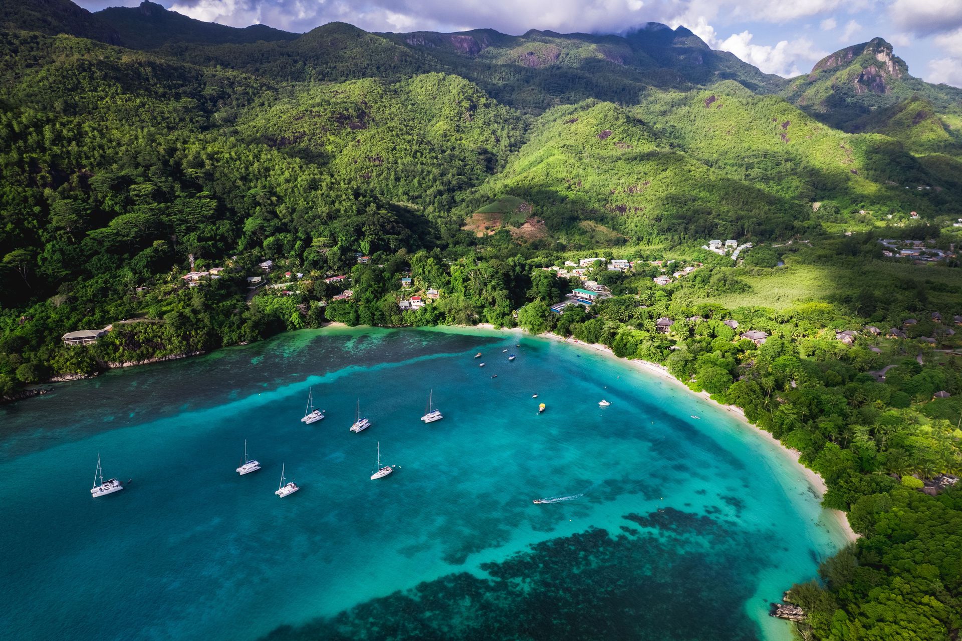 Magnifique vue aérienne des eaux turquoise de la baie de Beau Vallon, de la verdure luxuriante et des bateaux ancrés aux Seychelles.