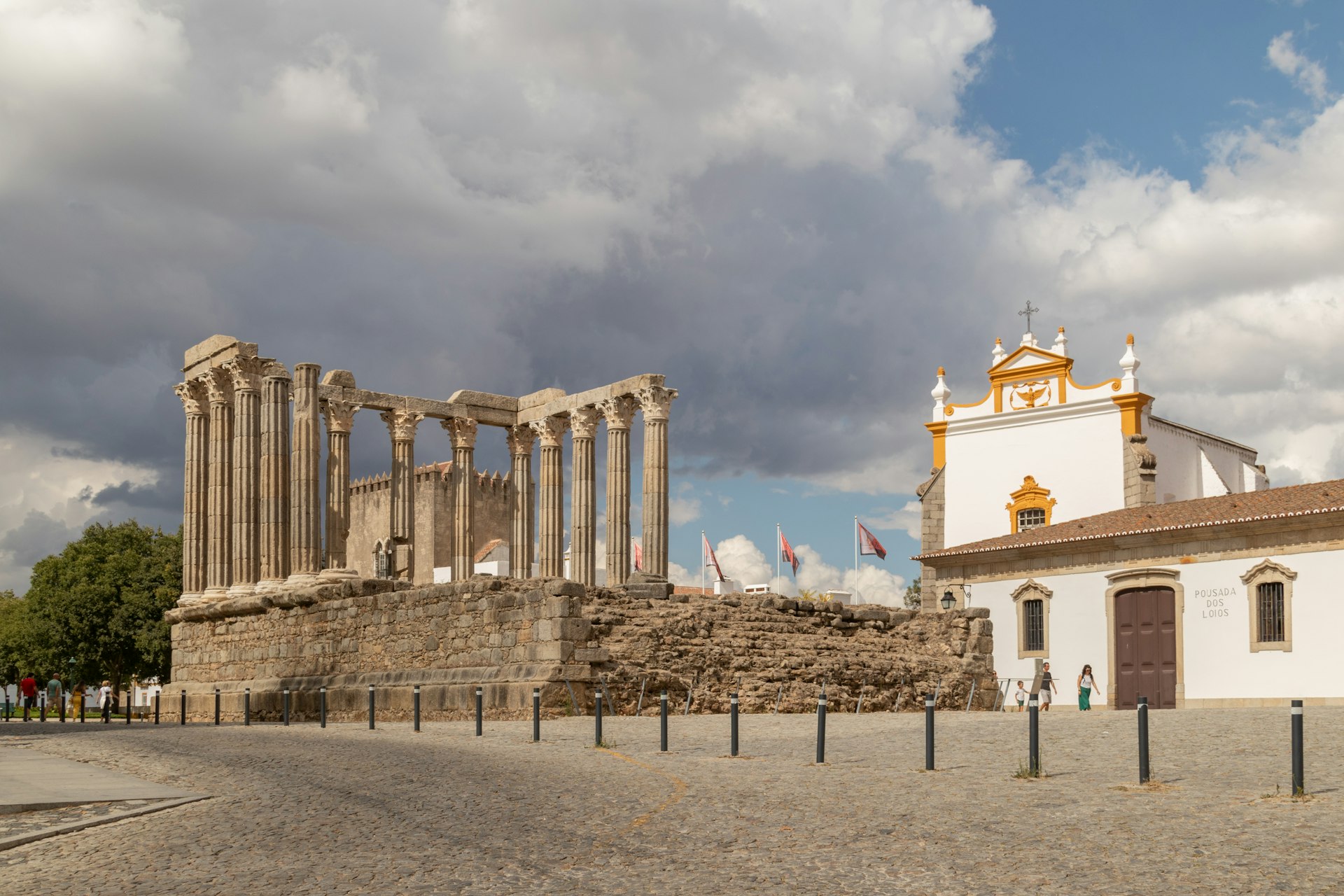 Le Temple romain d'Évora, colonnes corinthiennes en ruine sous un ciel orageux, face à la Pousada dos Lóios.