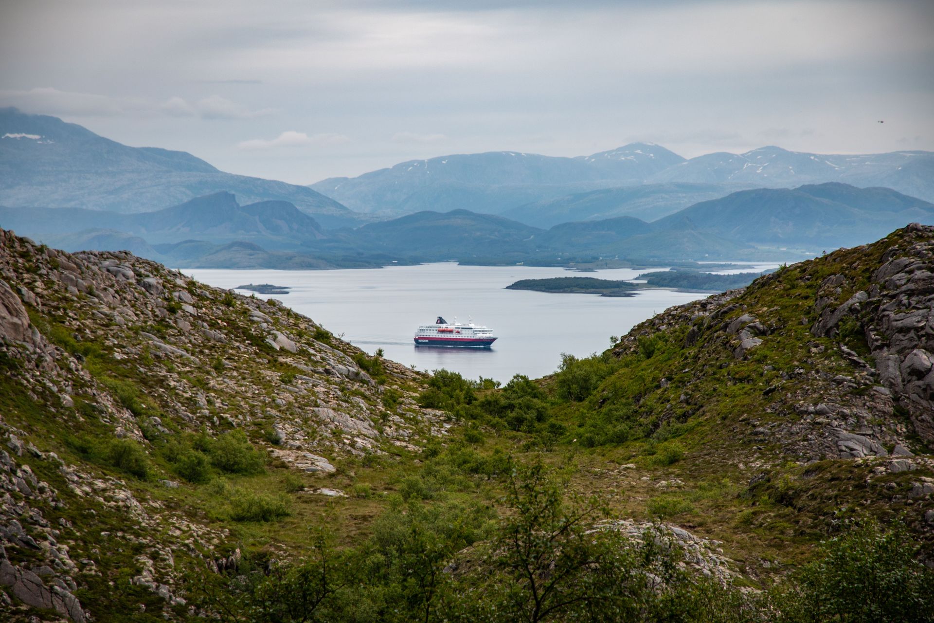 Vue magnifique d'un bateau de croisière dans un fjord entouré de montagnes à Nordland, en Norvège.