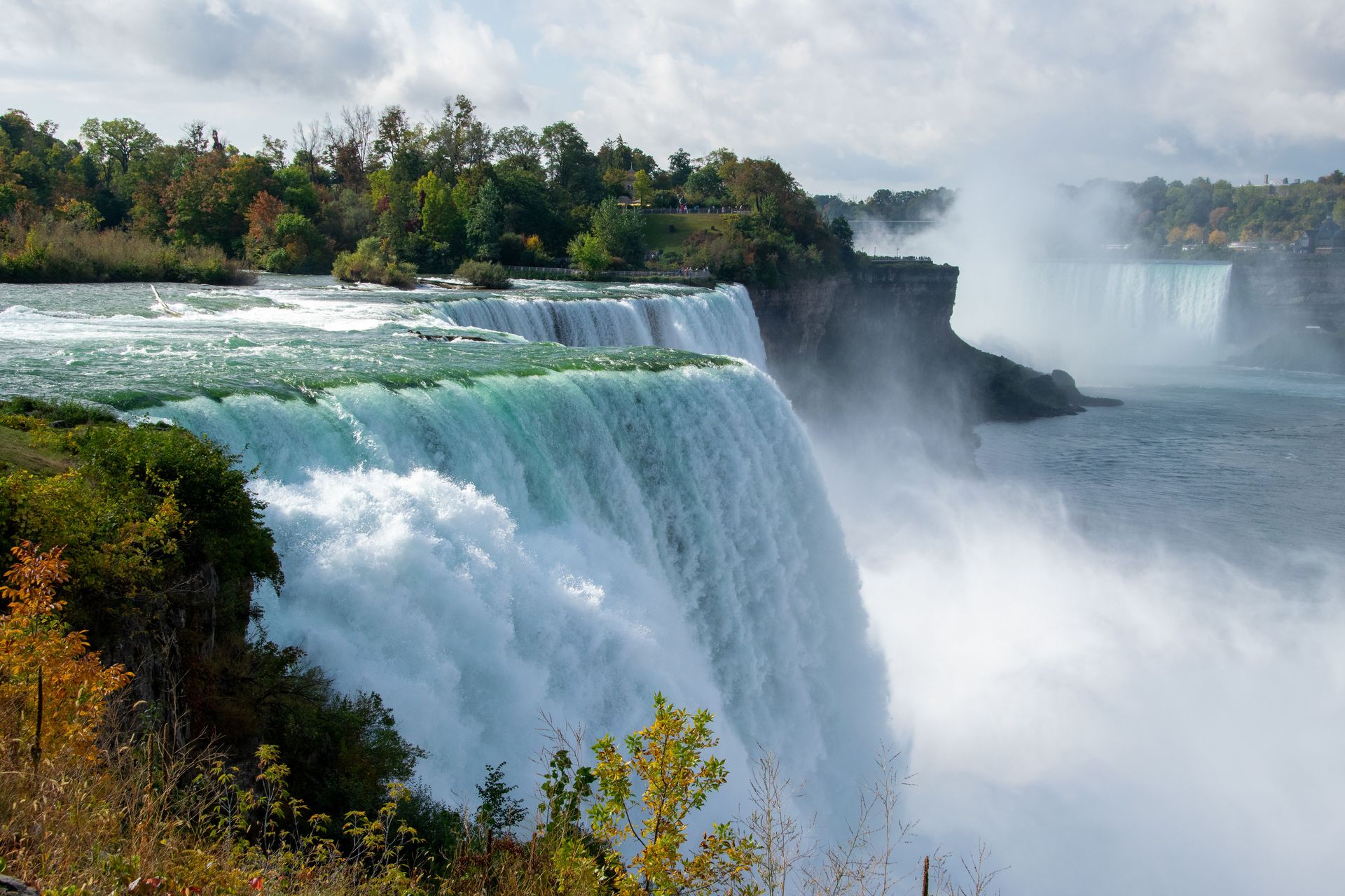 Superbe prise de vue des chutes du Niagara avec un feuillage d'automne luxuriant et des eaux en cascade.