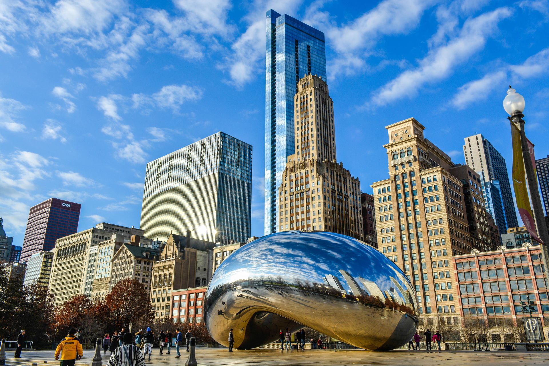 Vue de la sculpture emblématique Cloud Gate dans le Millennium Park de Chicago avec les gratte-ciel de la ville en arrière-plan.