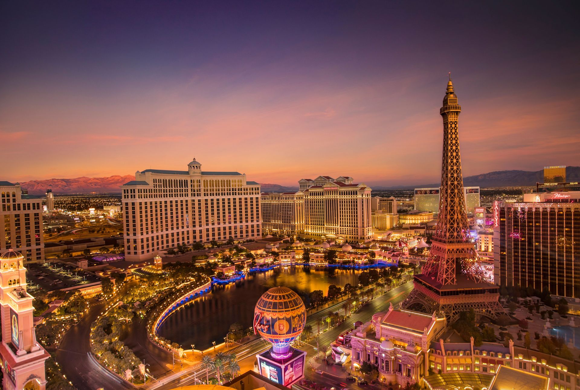 Vue aérienne époustouflante du Strip de Las Vegas au coucher de soleil avec la réplique emblématique de la Tour Eiffel et un paysage urbain vibrant.
