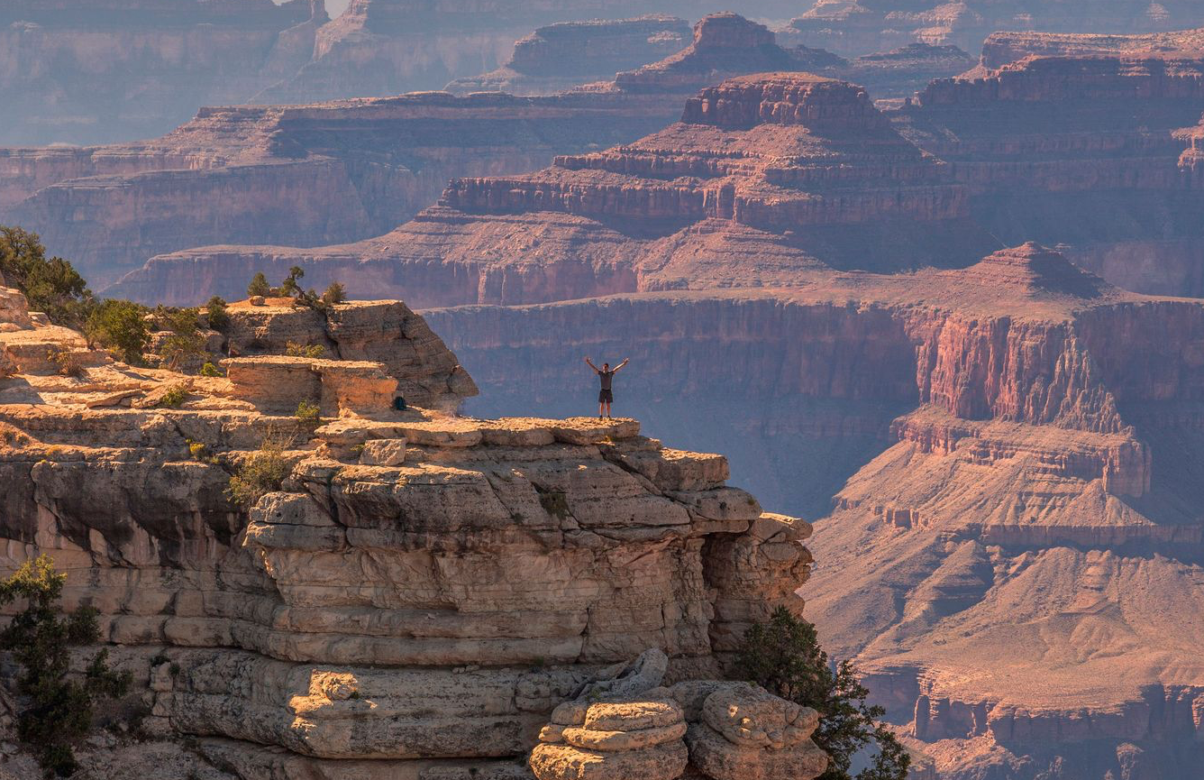 personne se tenant au bord du grand canyon
