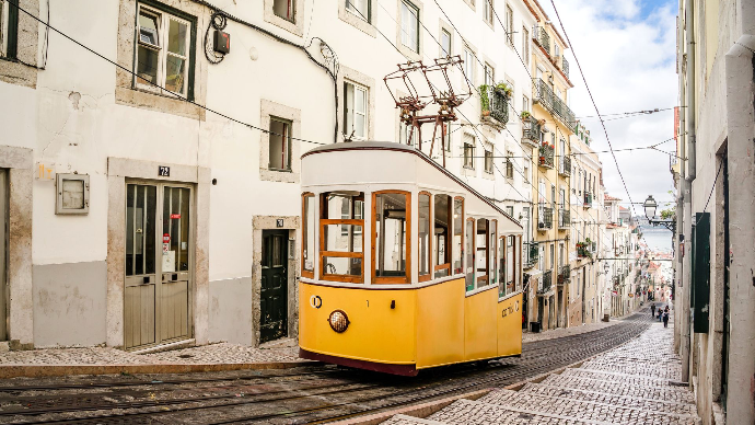 Funiculaire emblématique de la ville de Lisbonne au Portugal. Le funiculaire est blanc et jaune, il est en train de monter la pente